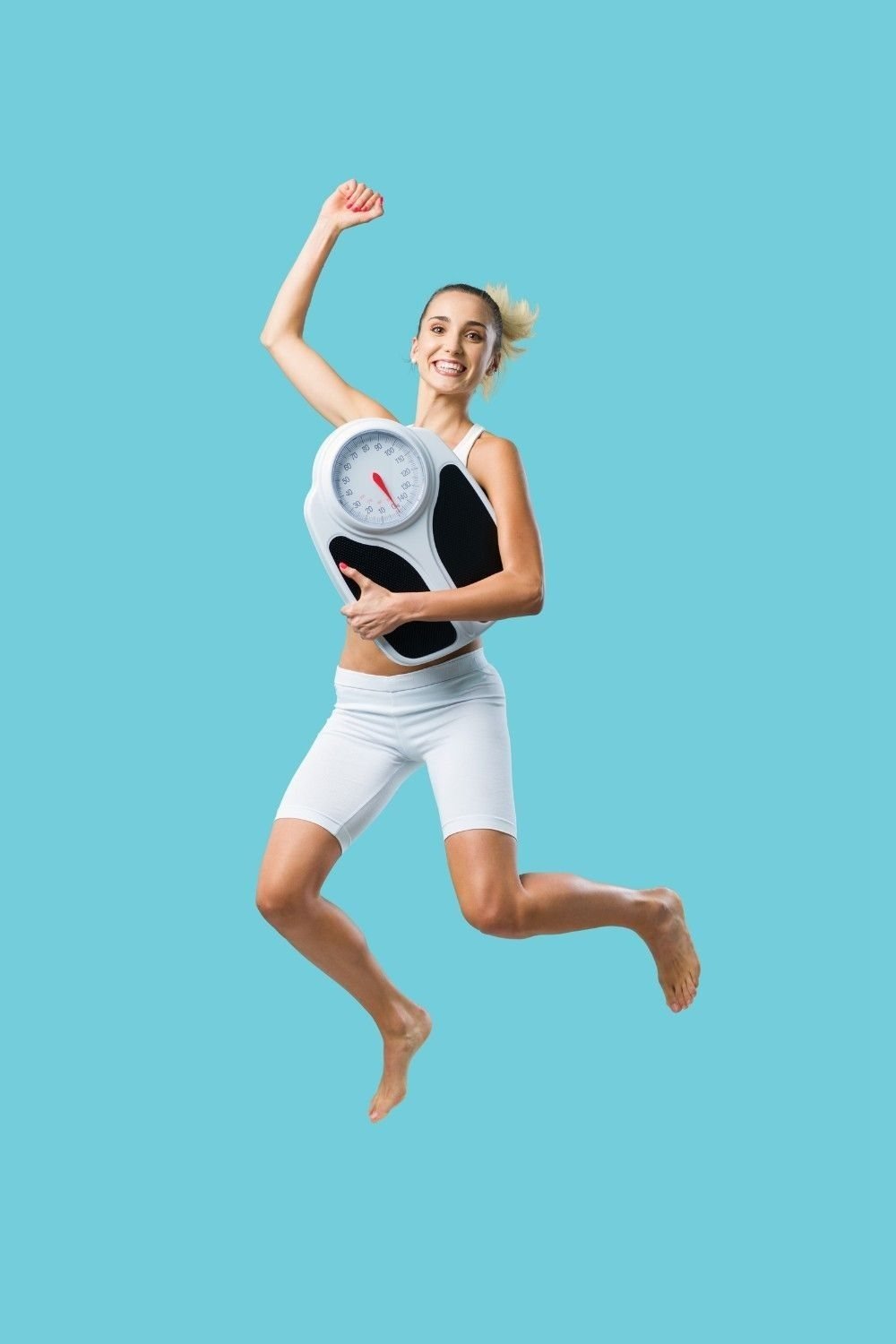 Woman jumping while holding bathroom scales, representing weight management goals in Ireland