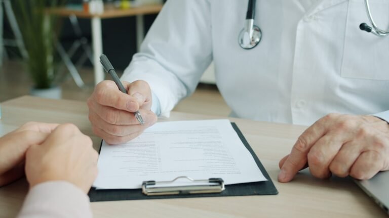 GLP-1 treatment in Ireland, explained Doctor writing on patient chart during medical consultation in Ireland